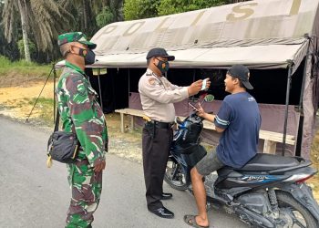 Stop Pengguna jalan Polsek Kerumutan bersama Babinsa Bagikan Masker Gratis